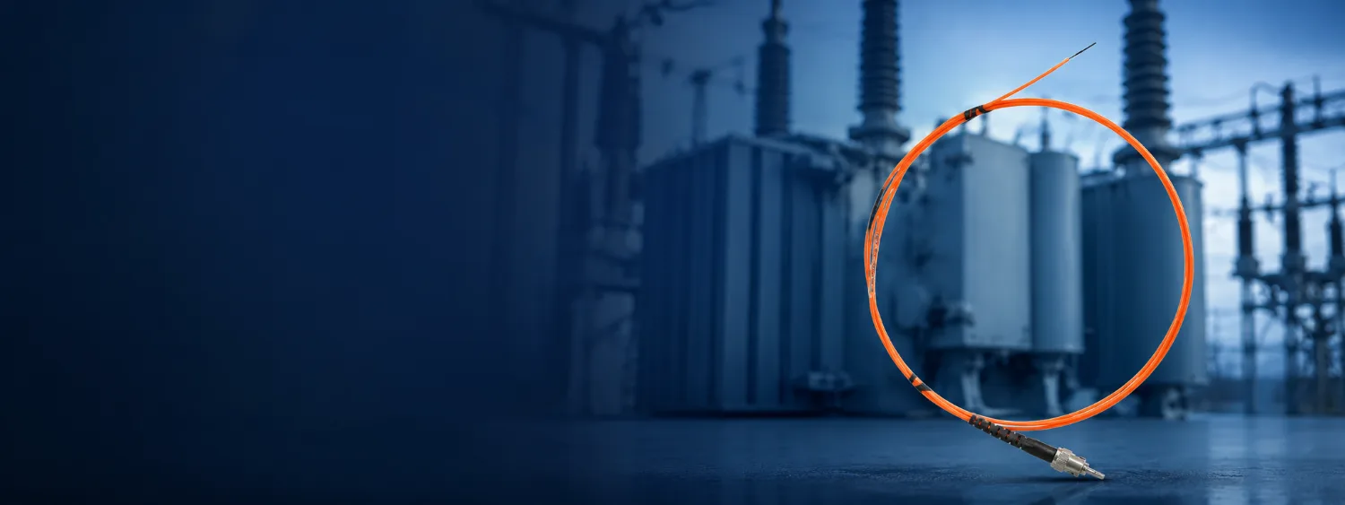 Orange fiber optic probe at high-voltage transformer equipment